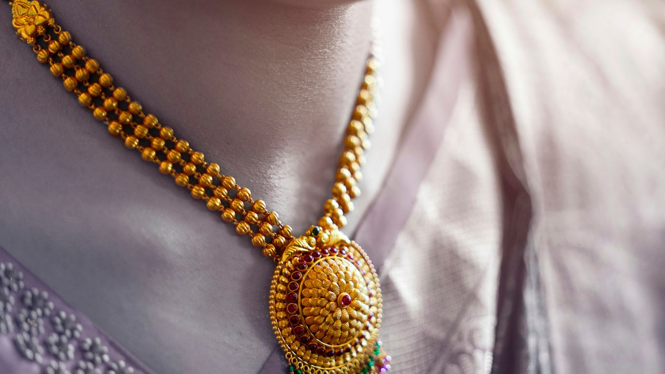 person wearing gold and silver necklace