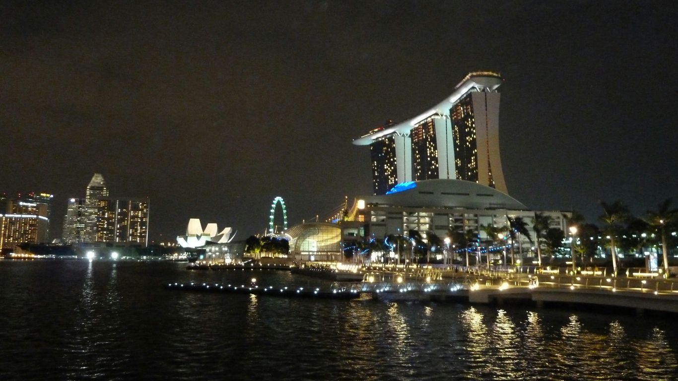 white and brown concrete building near body of water during night time