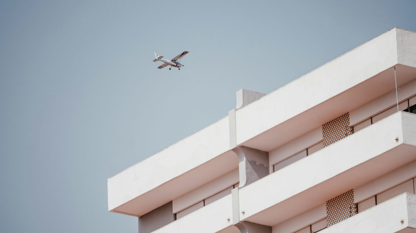 white monoplane passing thru building