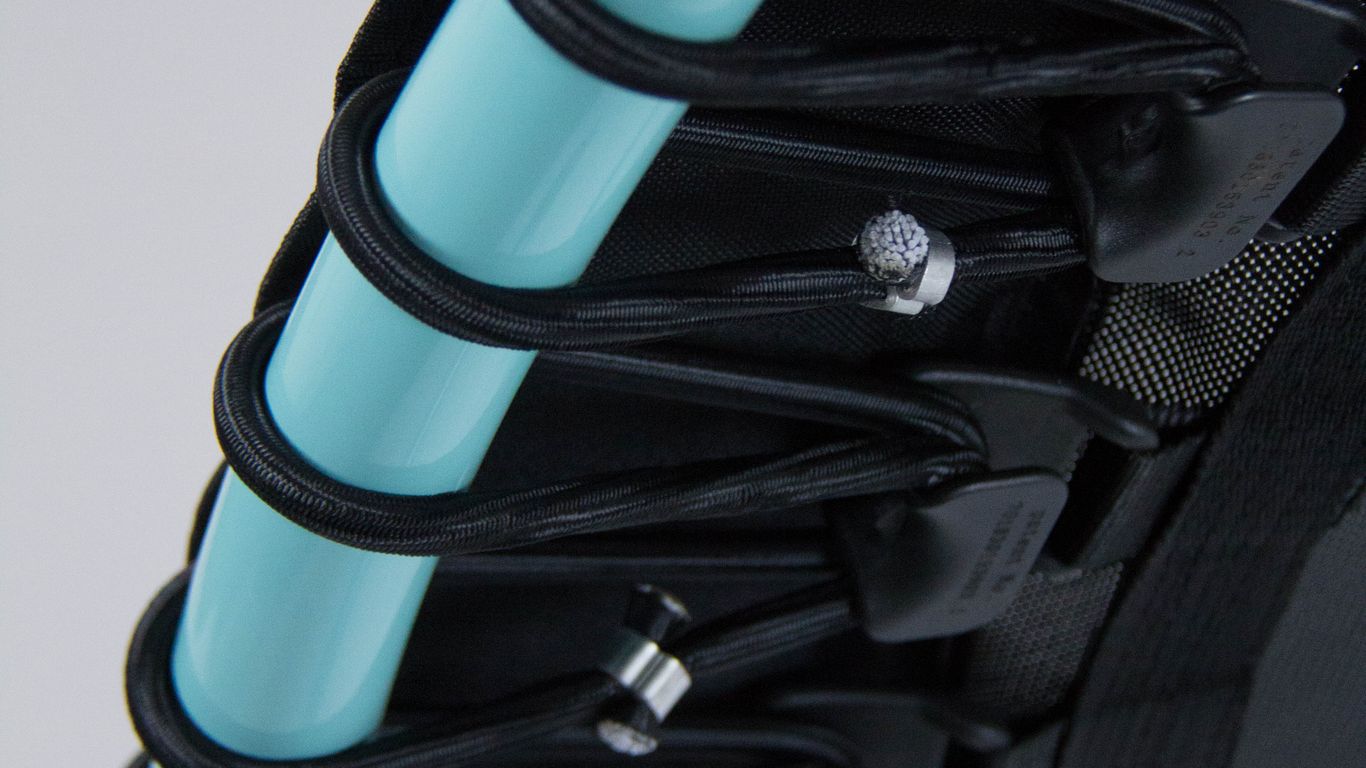 Close-up of a trampoline's edge with blue frame and cords.