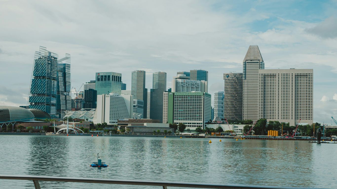A modern city skyline reflecting on the water.