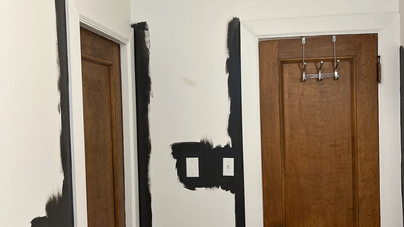 Interior doors being painted with dark trim and white walls.