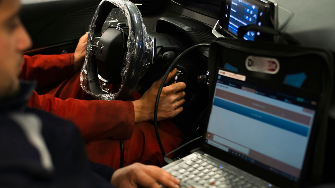 Technician diagnosing a vehicle computer