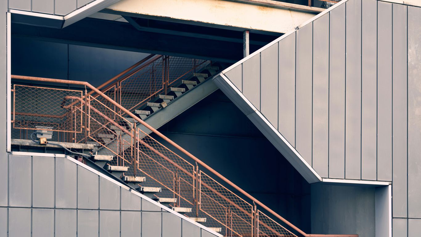 a metal stair case next to a building