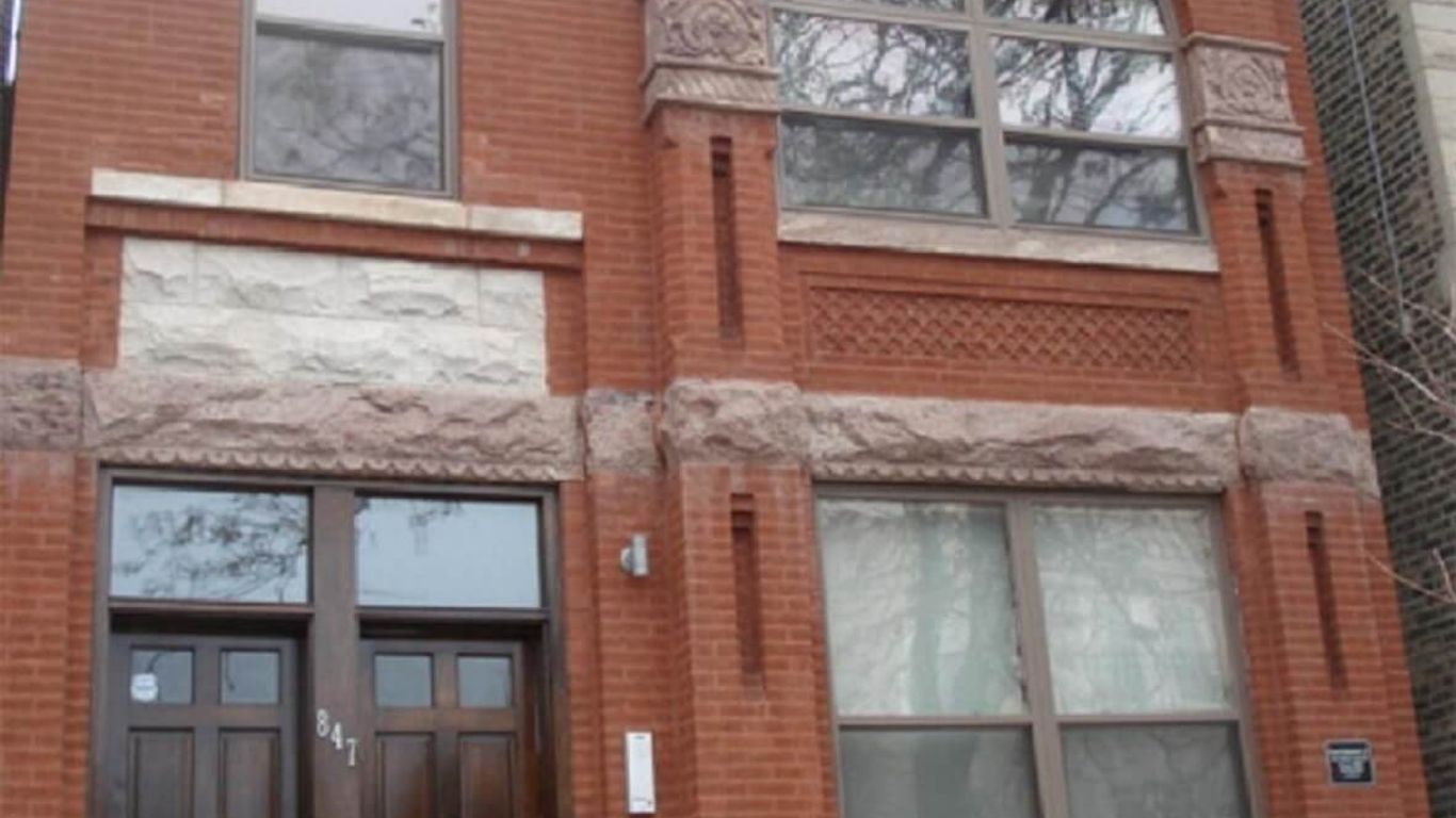 Red brick building with arched window and decorative stone accents.