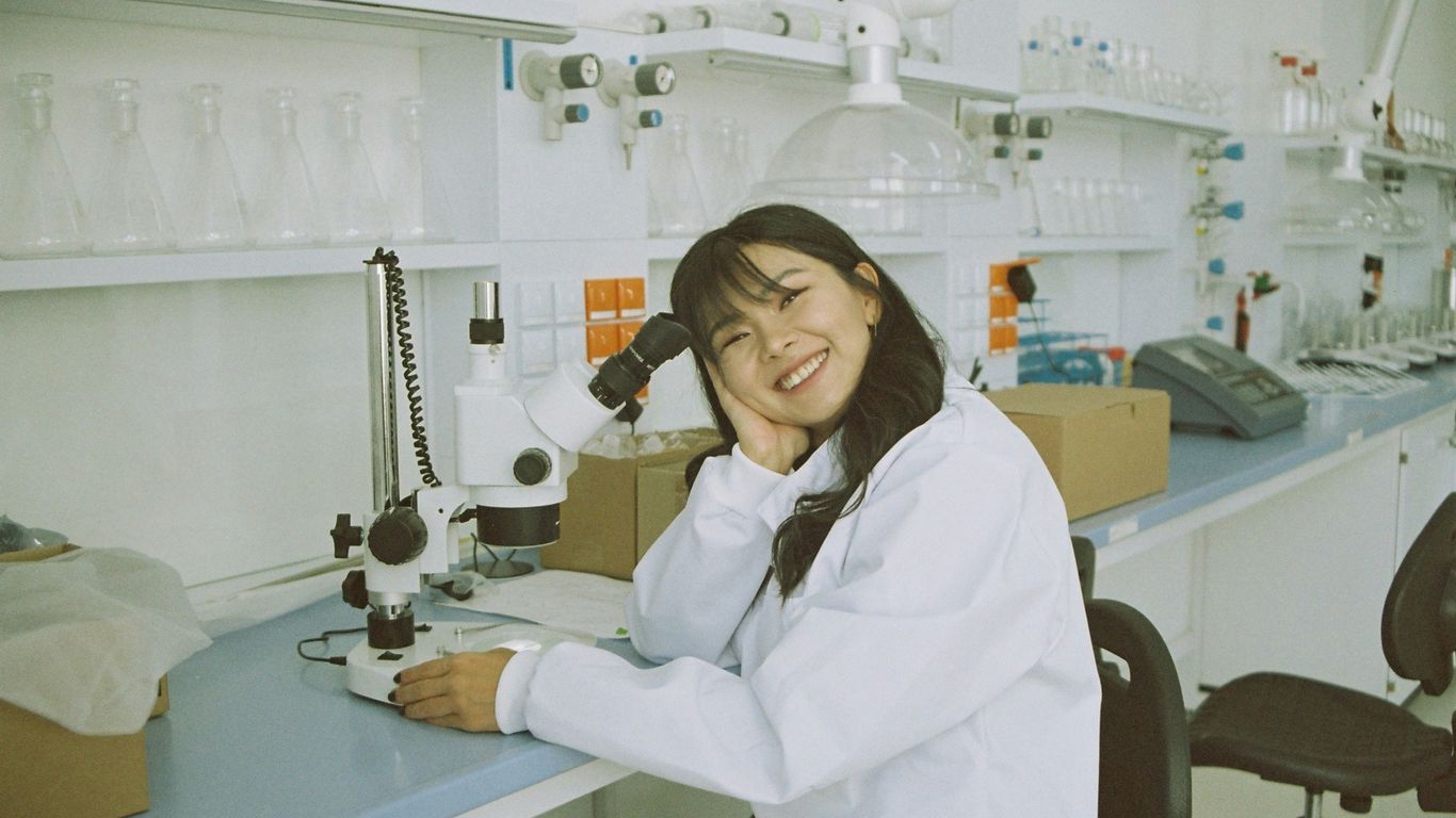 woman in white laboratory gown holding black microphone
