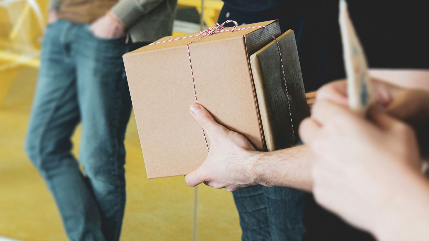 una persona sosteniendo una caja marrón con una cuerda