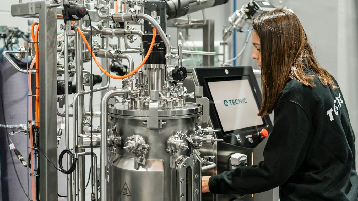 A woman operates complex scientific equipment.