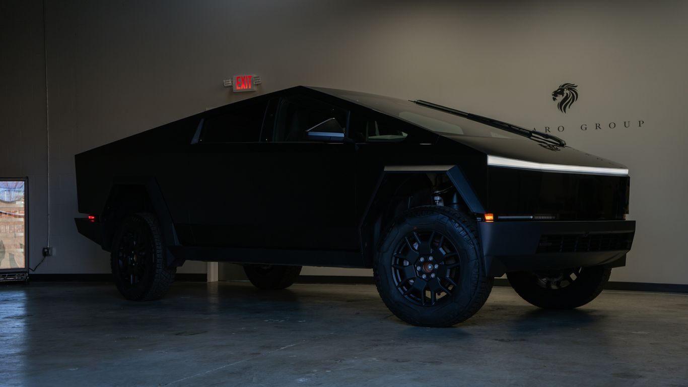 A black futuristic electric truck parked indoors.