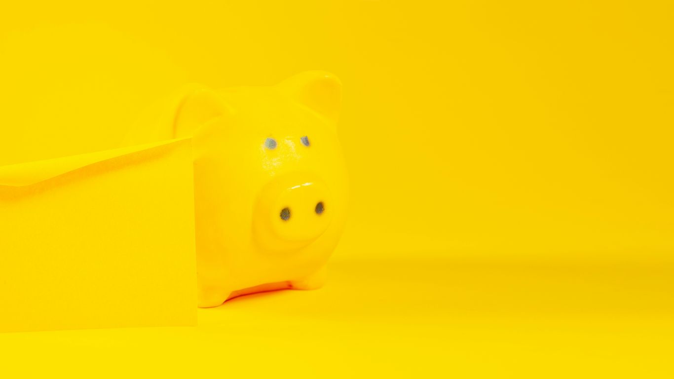 A yellow piggy bank sits against a yellow background.