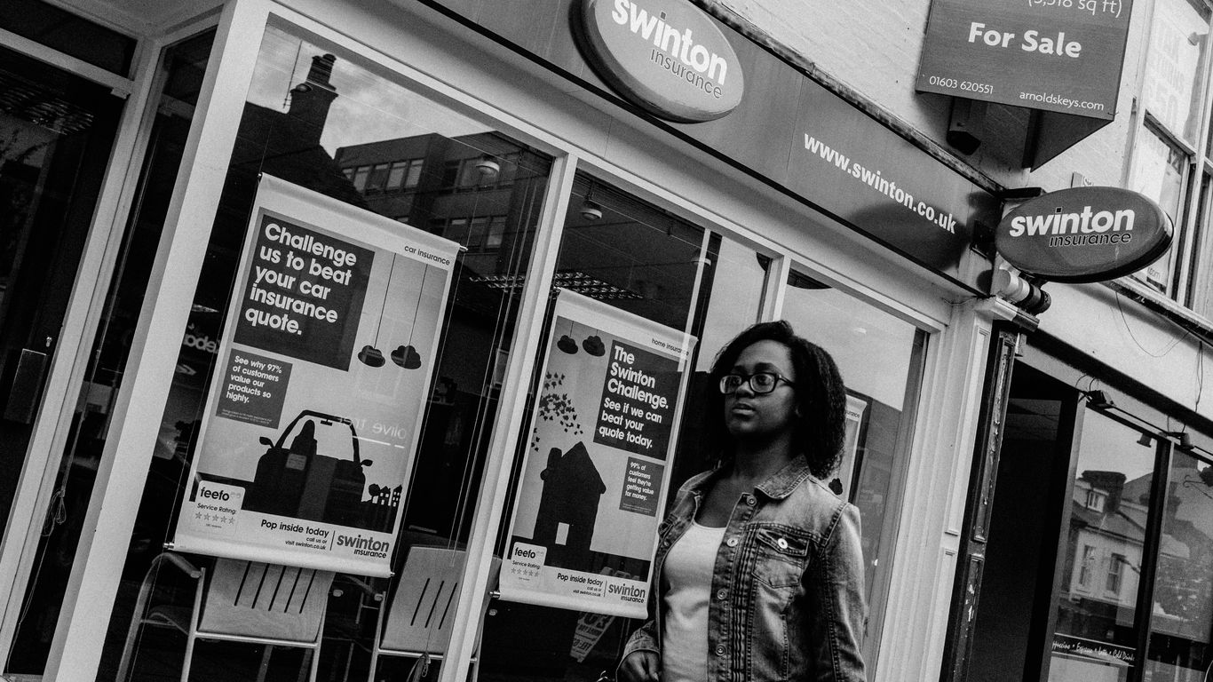 Woman walks past estate agent window