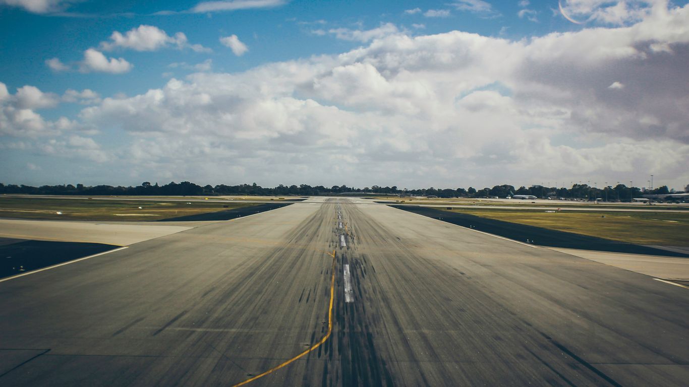 Wide runway beside Singapore city buildings