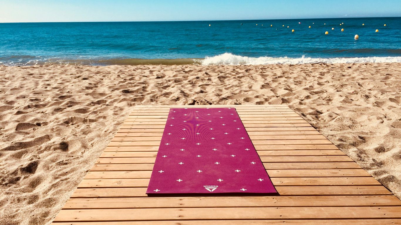 Folded microfiber towel beside yoga mat