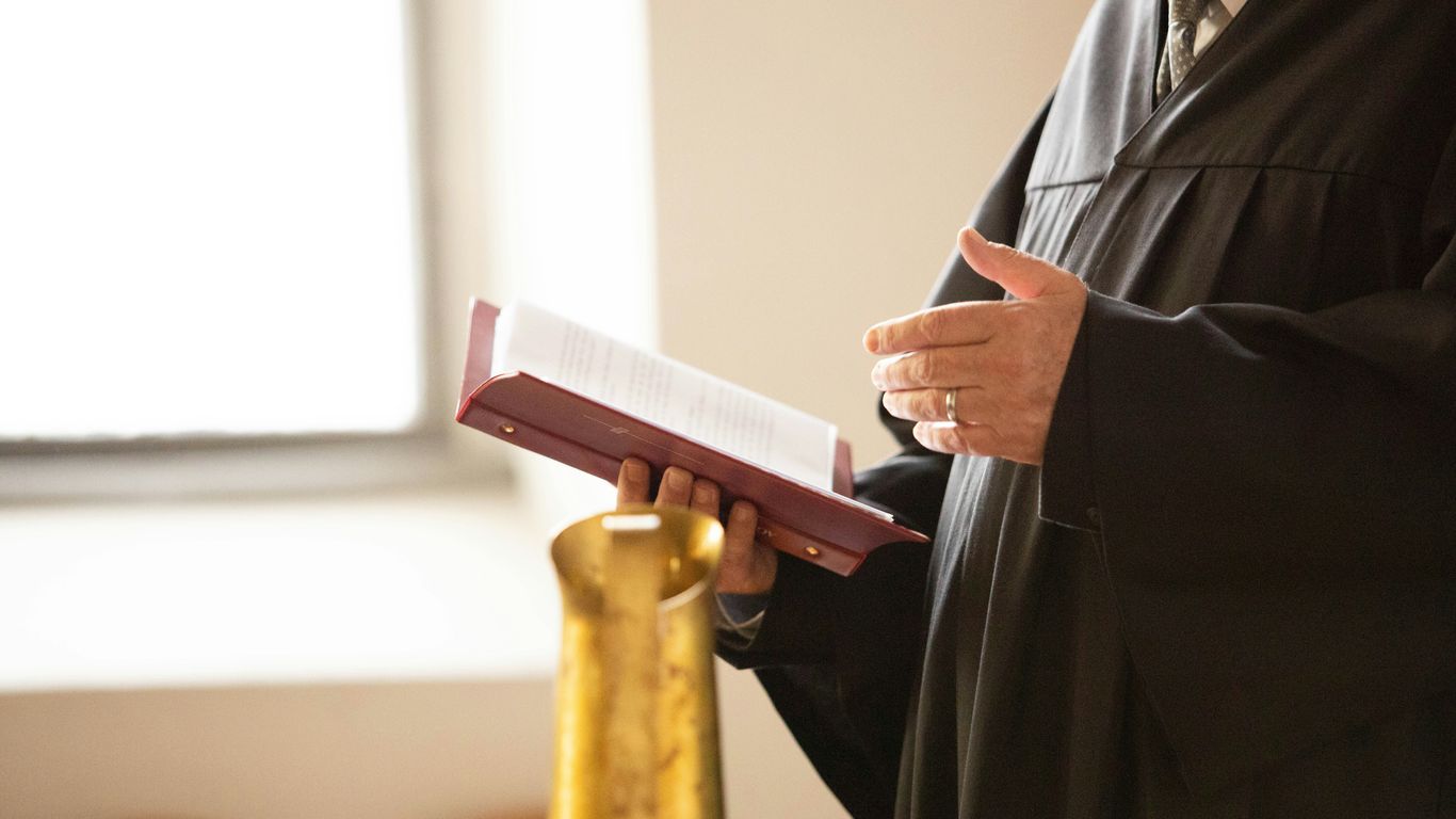 a man in a black robe holding a book