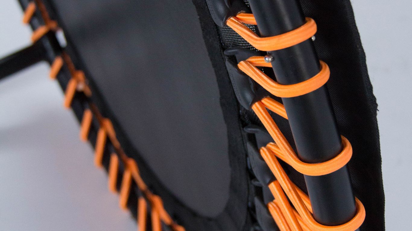 Close-up of a mini trampoline with orange elastic bands.