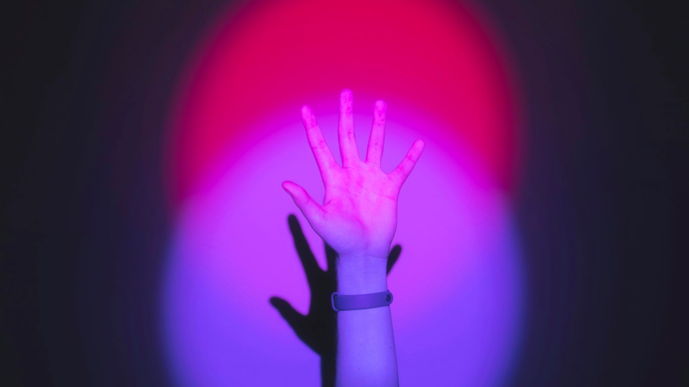 person holding pink heart balloon