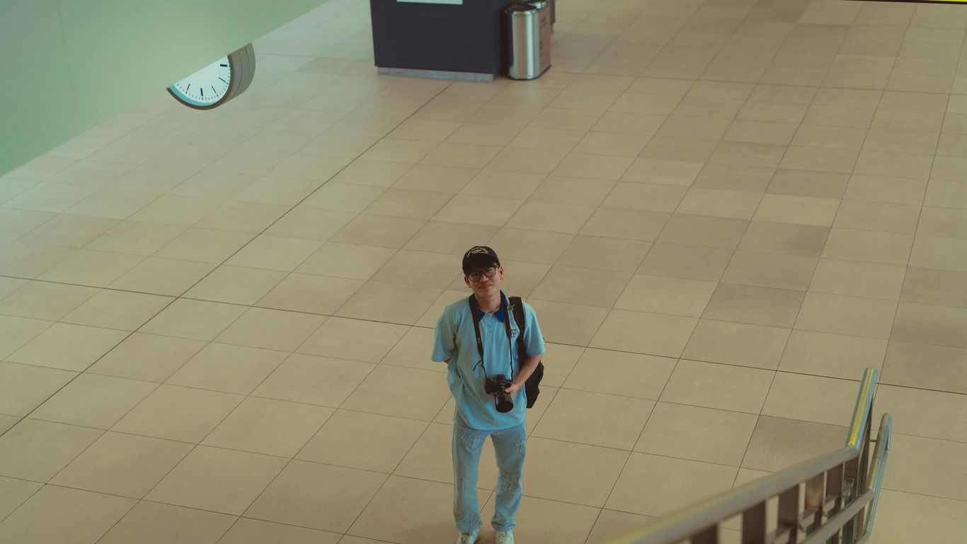 A man in a blue suit walking down a hall