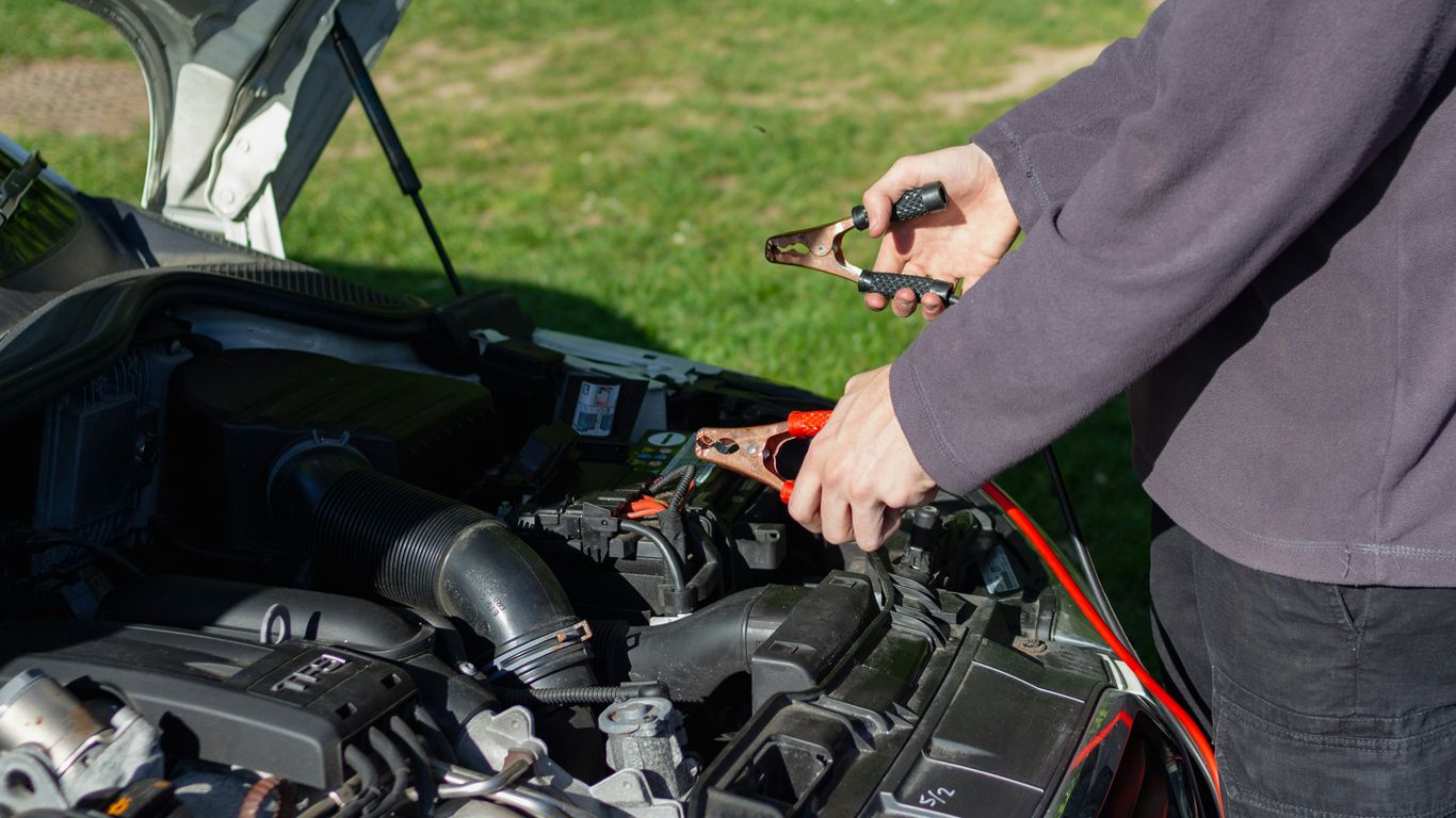 Mechanic checking car battery voltage