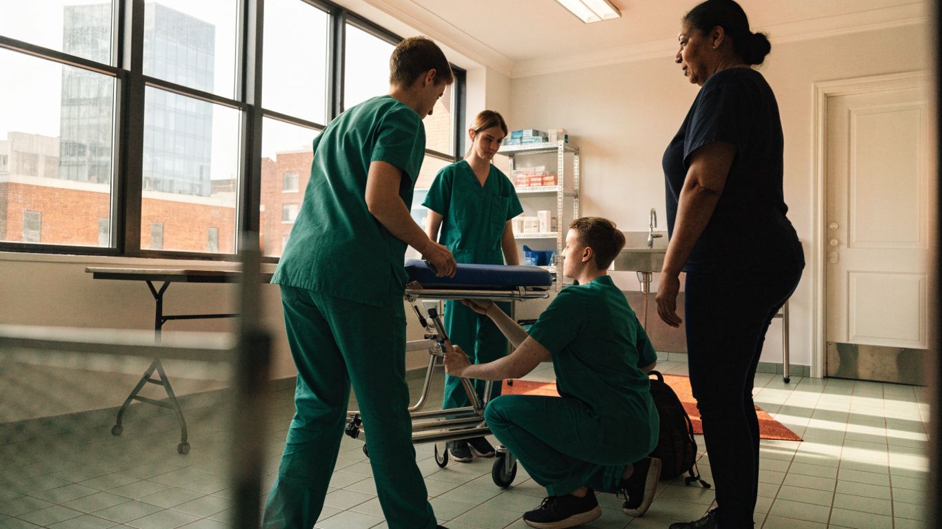 Students practising nursing assistant skills in a classroom
