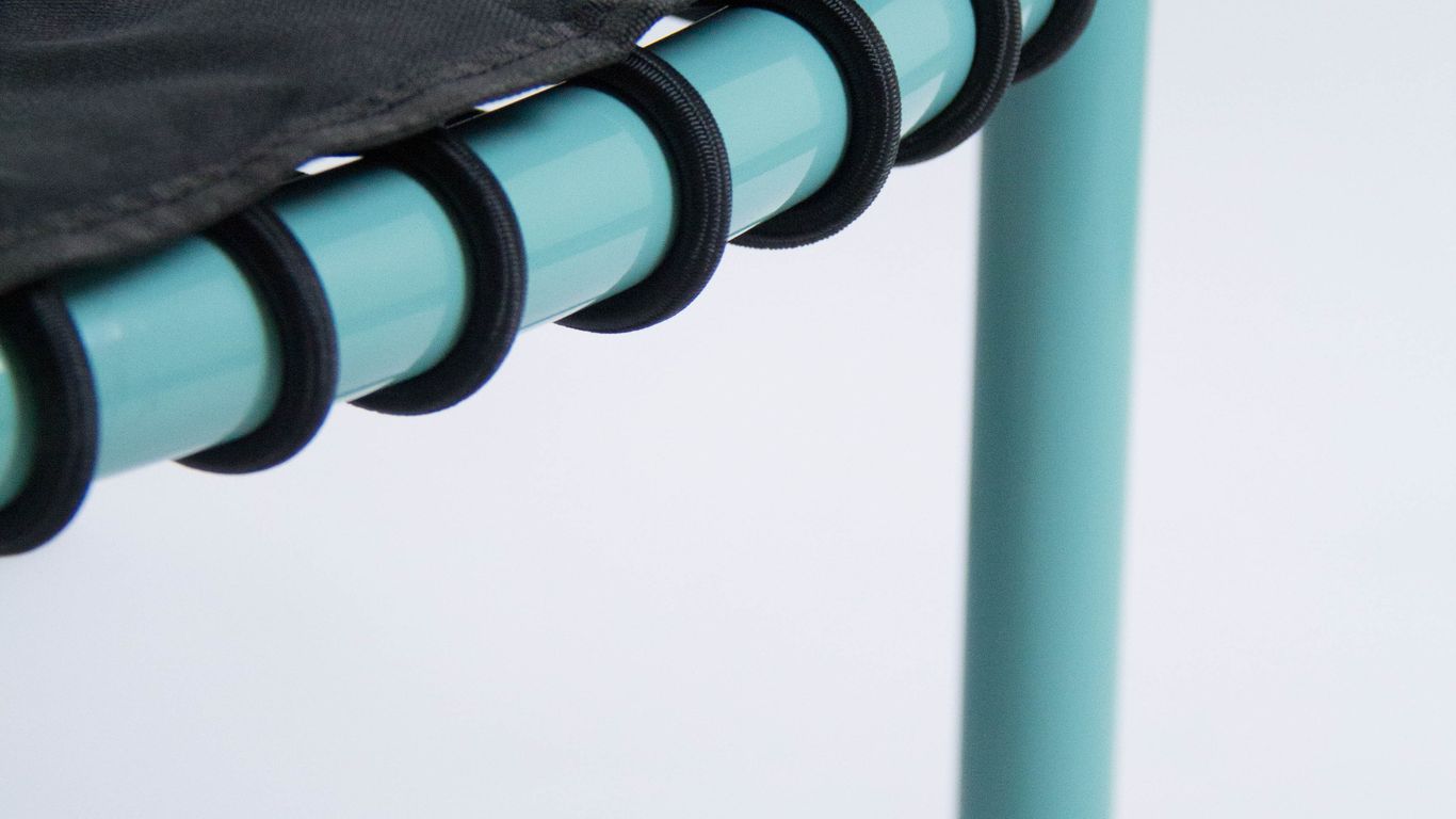 Close-up of a mini trampoline's corner with blue legs.