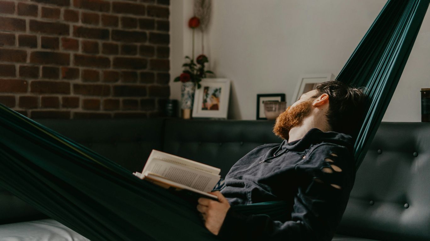 man in black jacket reading book