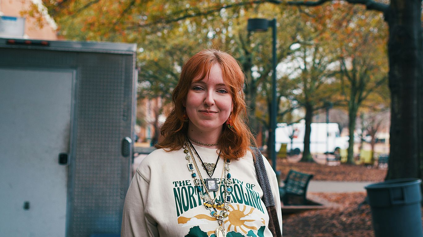 A woman standing next to a trash can