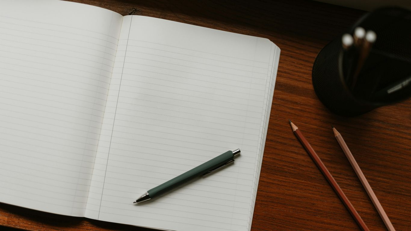 A clean desk with a pen and writing pad