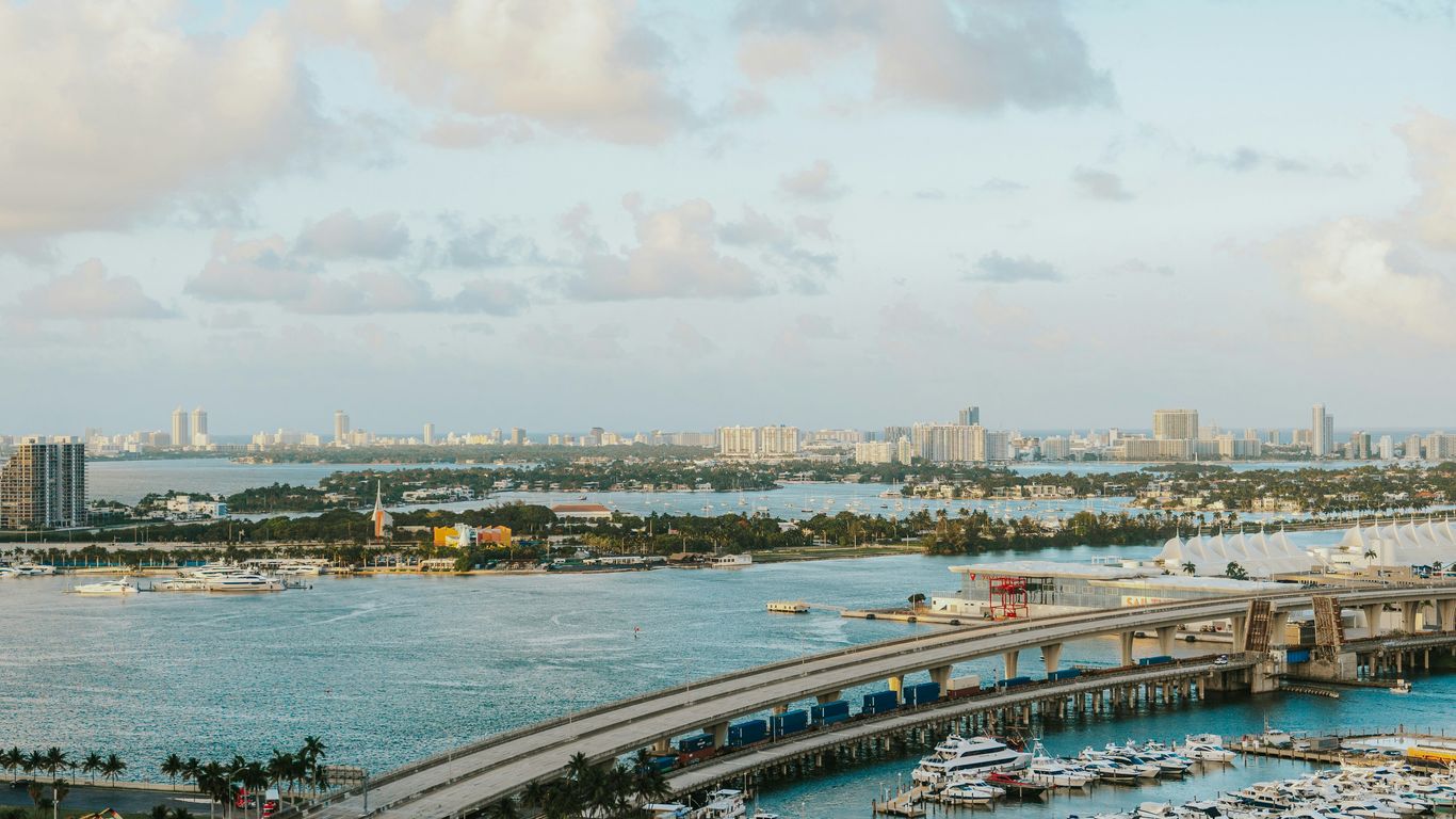 A diverse film crew setting up gear near the Miami waterfront