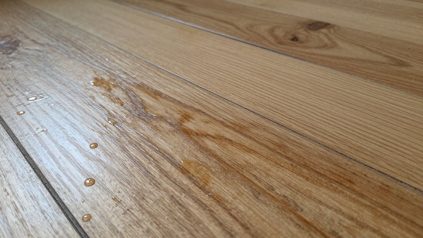 Water damaged wood floor with stains and warping.