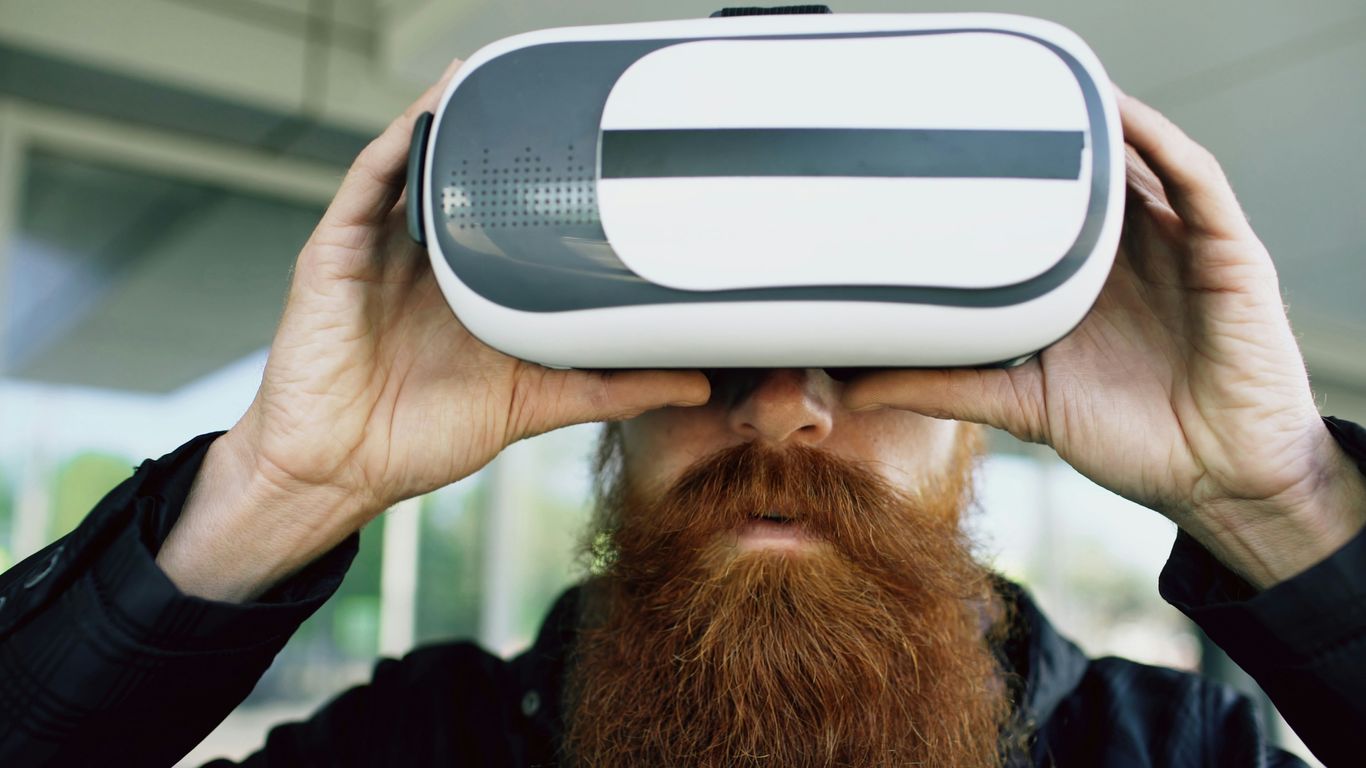 Man with long beard wearing virtual reality headset.