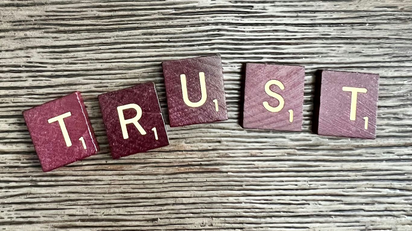 trust spelled with wooden letter blocks on a table