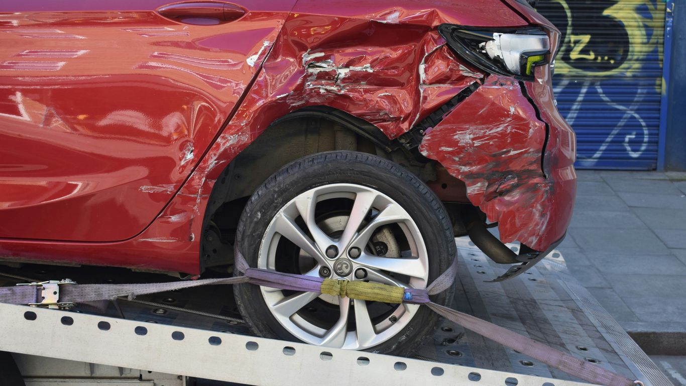 a red car is on a flatbed tow truck