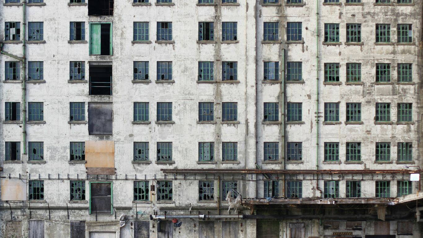 an old building with lots of windows next to a body of water