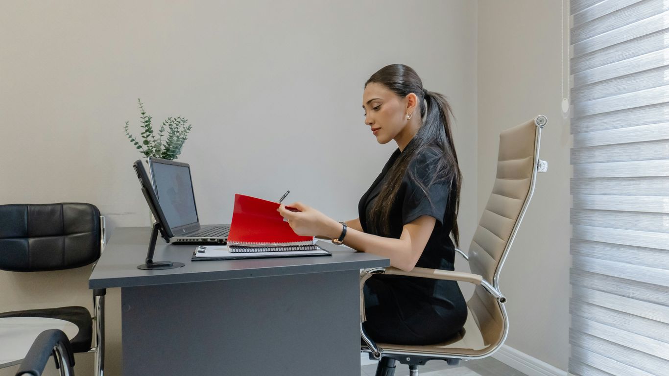Woman working at a desk with a laptop and laptop.