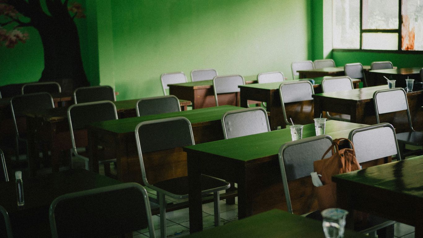 green and white chairs near green wall