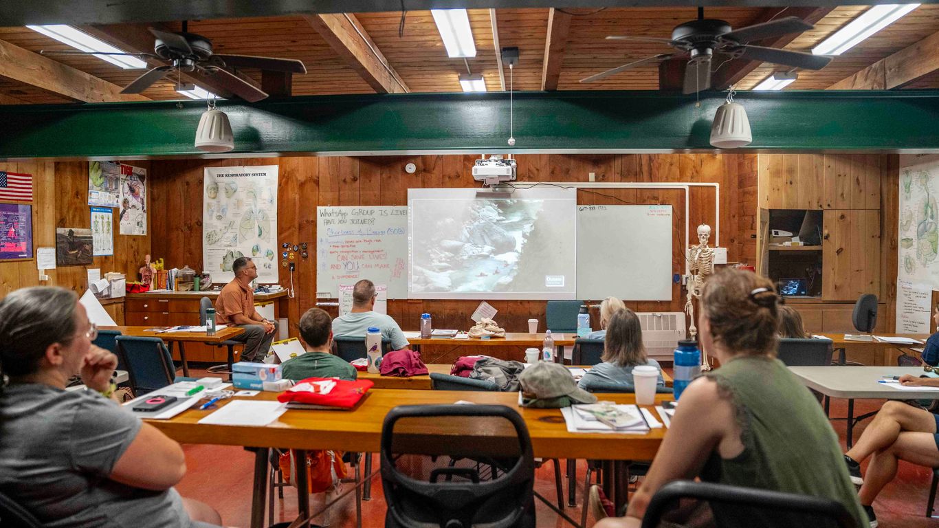 People attending a class with a projector screen.