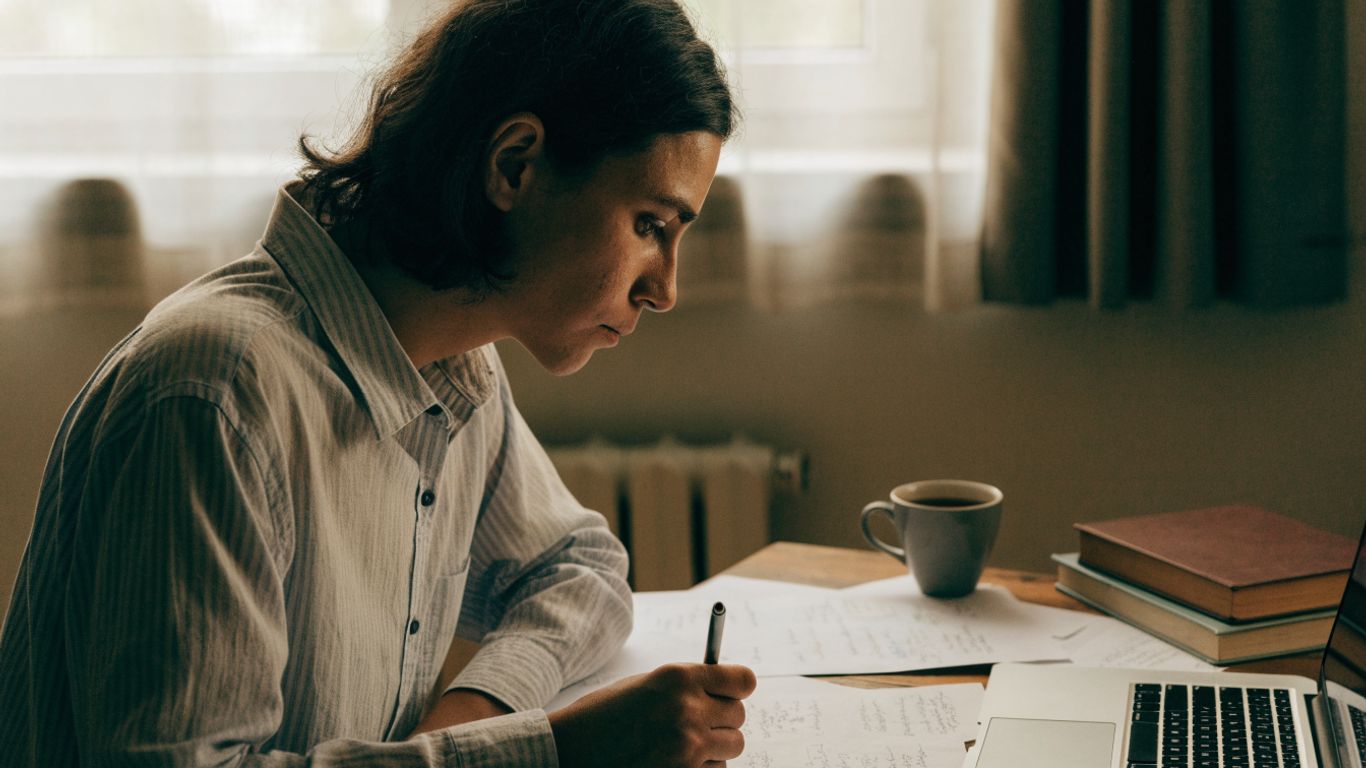 Learner reviewing course notes beside a laptop