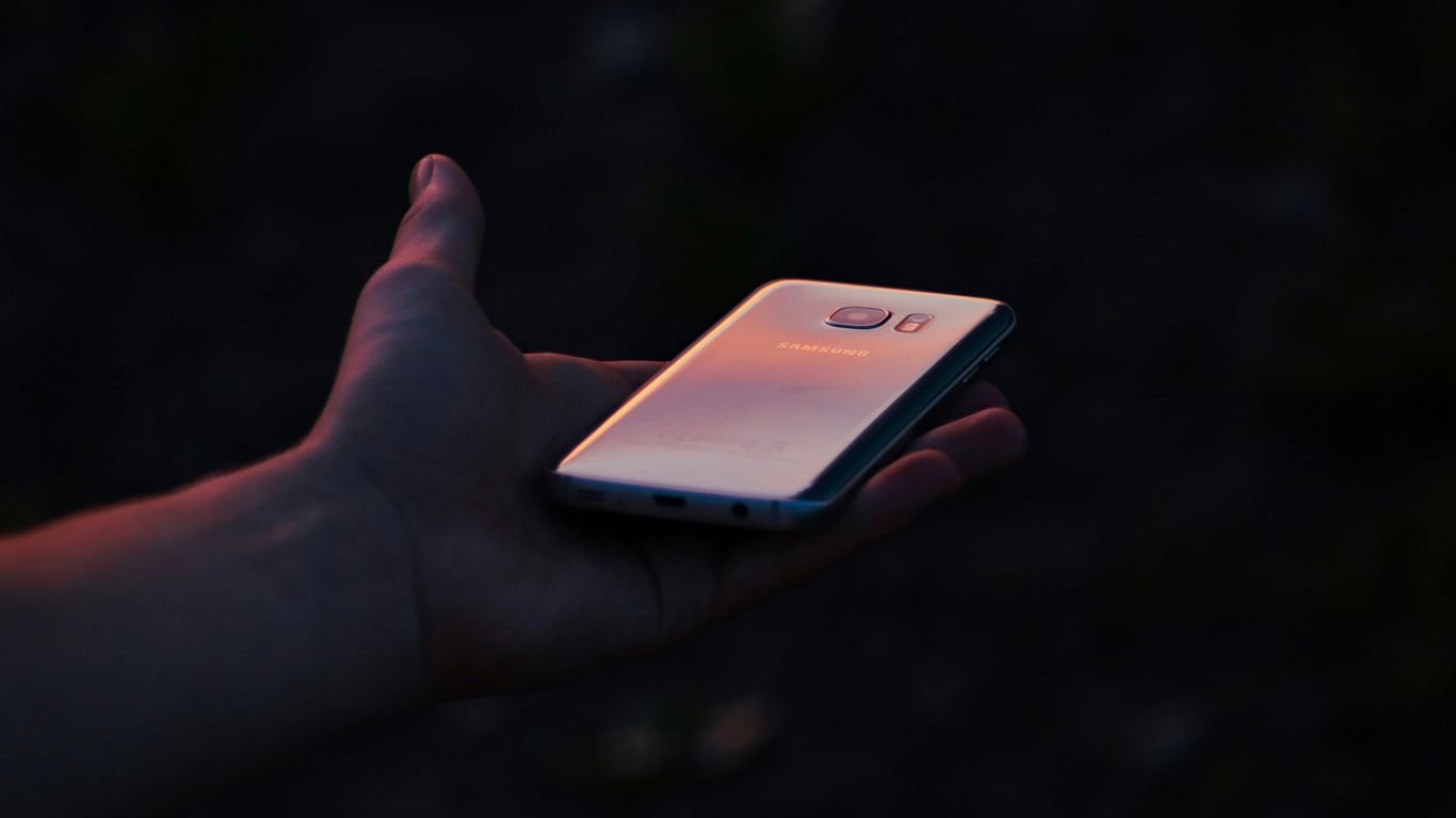 a person holding a cell phone in their hand