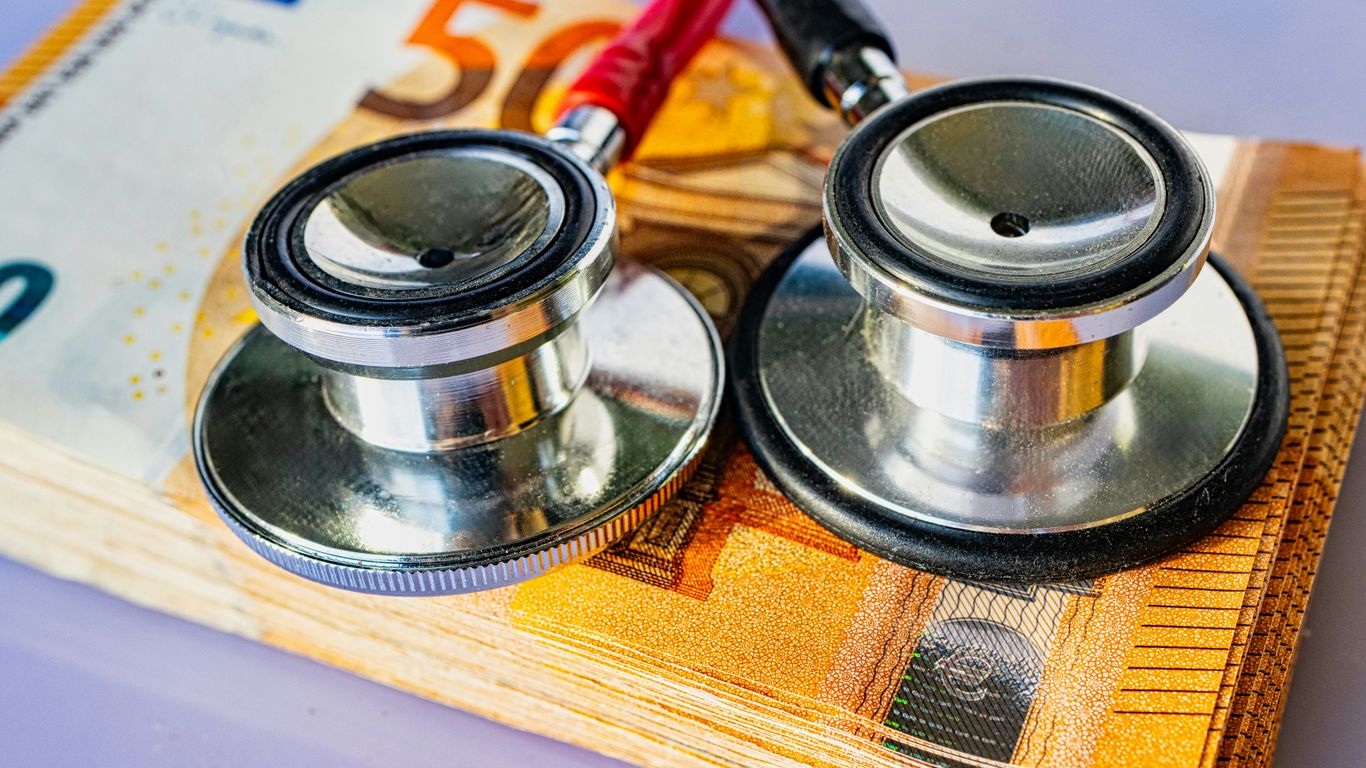 a pair of stethoscopes sitting on top of a pile of money