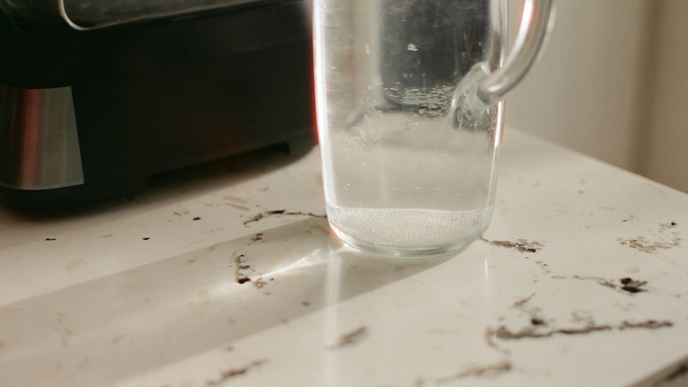Clear glass pitcher with water on a countertop.