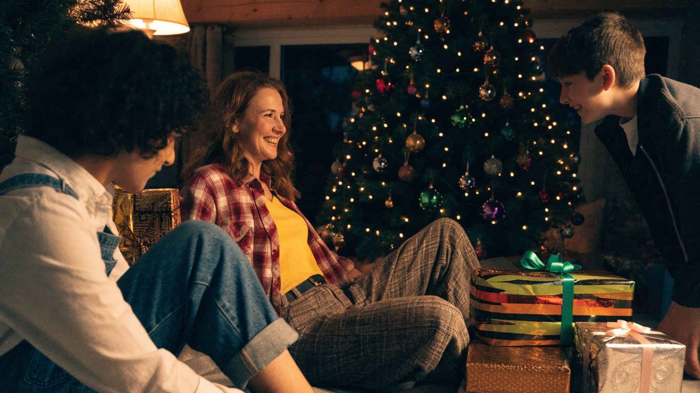 A festive family gathered around a glowing Christmas tree