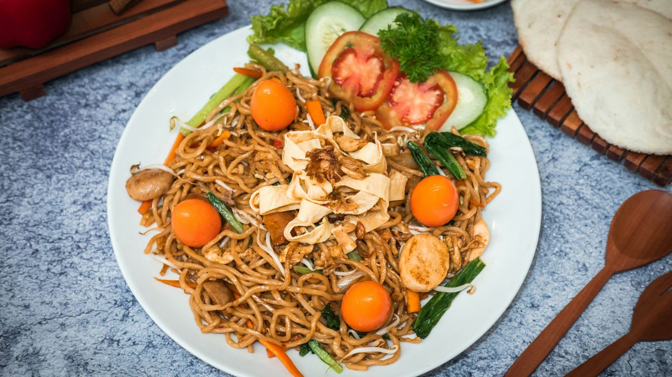 a white plate topped with noodles and veggies