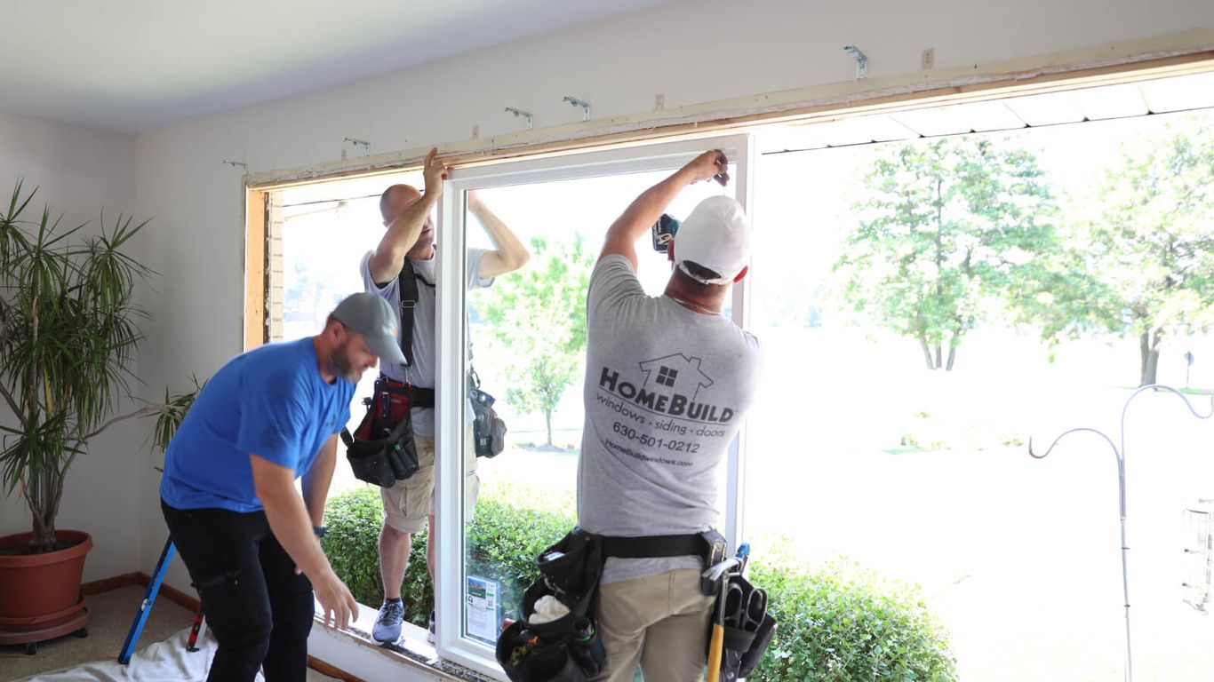 Workers installing a new window in a home.