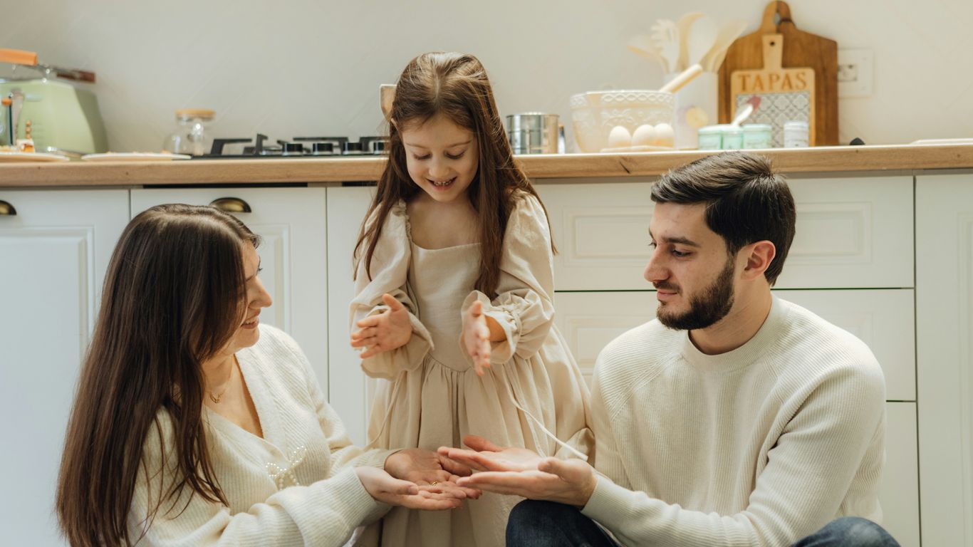 A group of people sitting around in a kitchen
