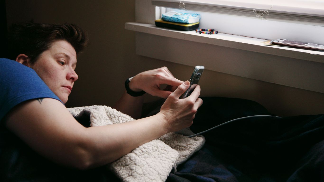 man in black shirt holding black smartphone
