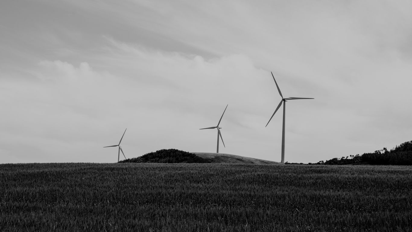 grayscale photo of line windmills