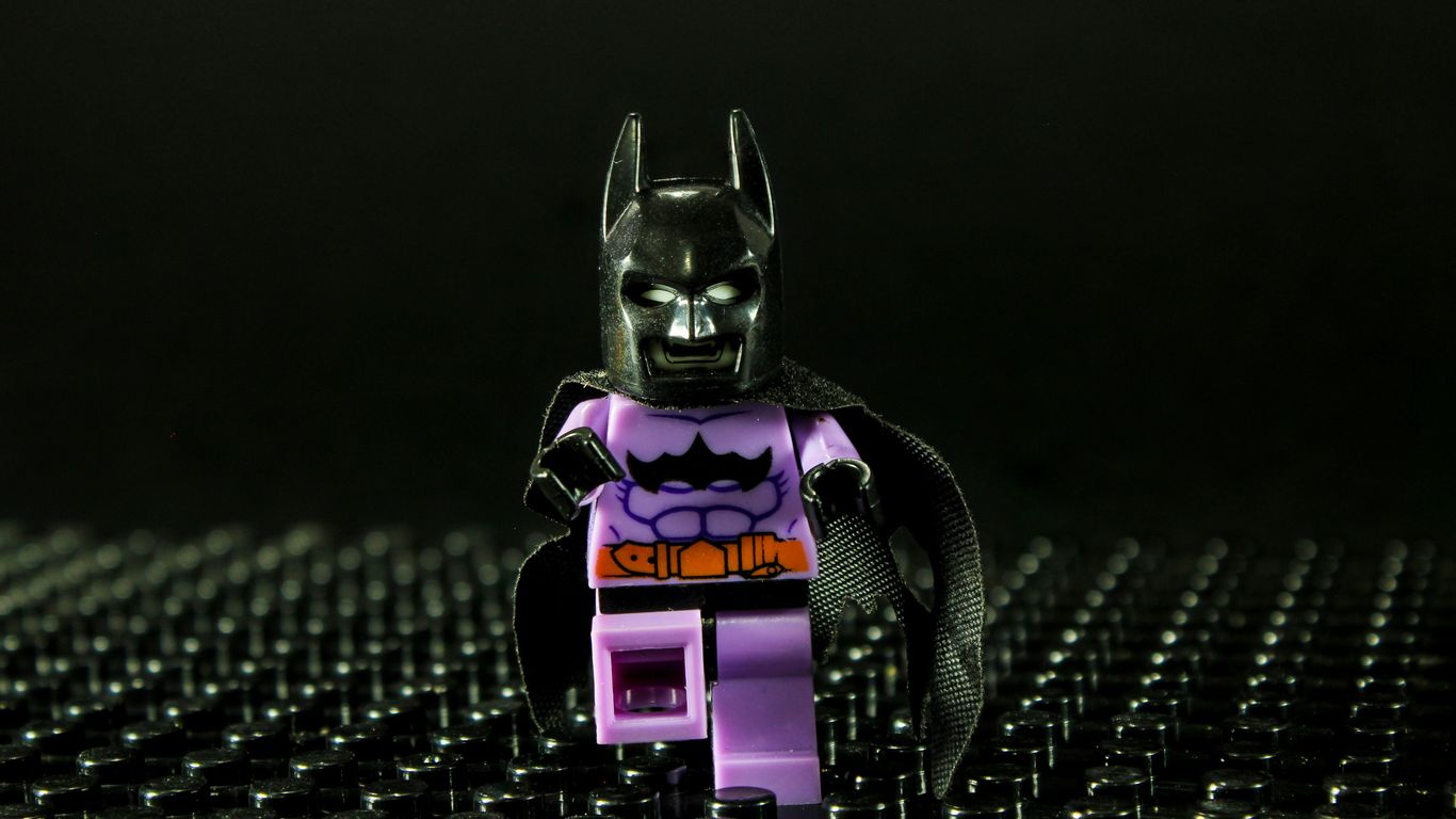 Lego batman figure in purple suit on black background
