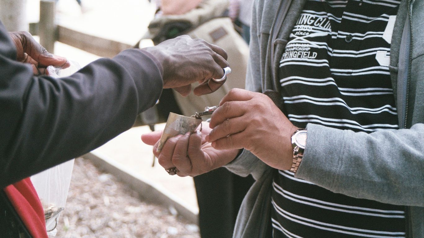 person standing while holding banknote