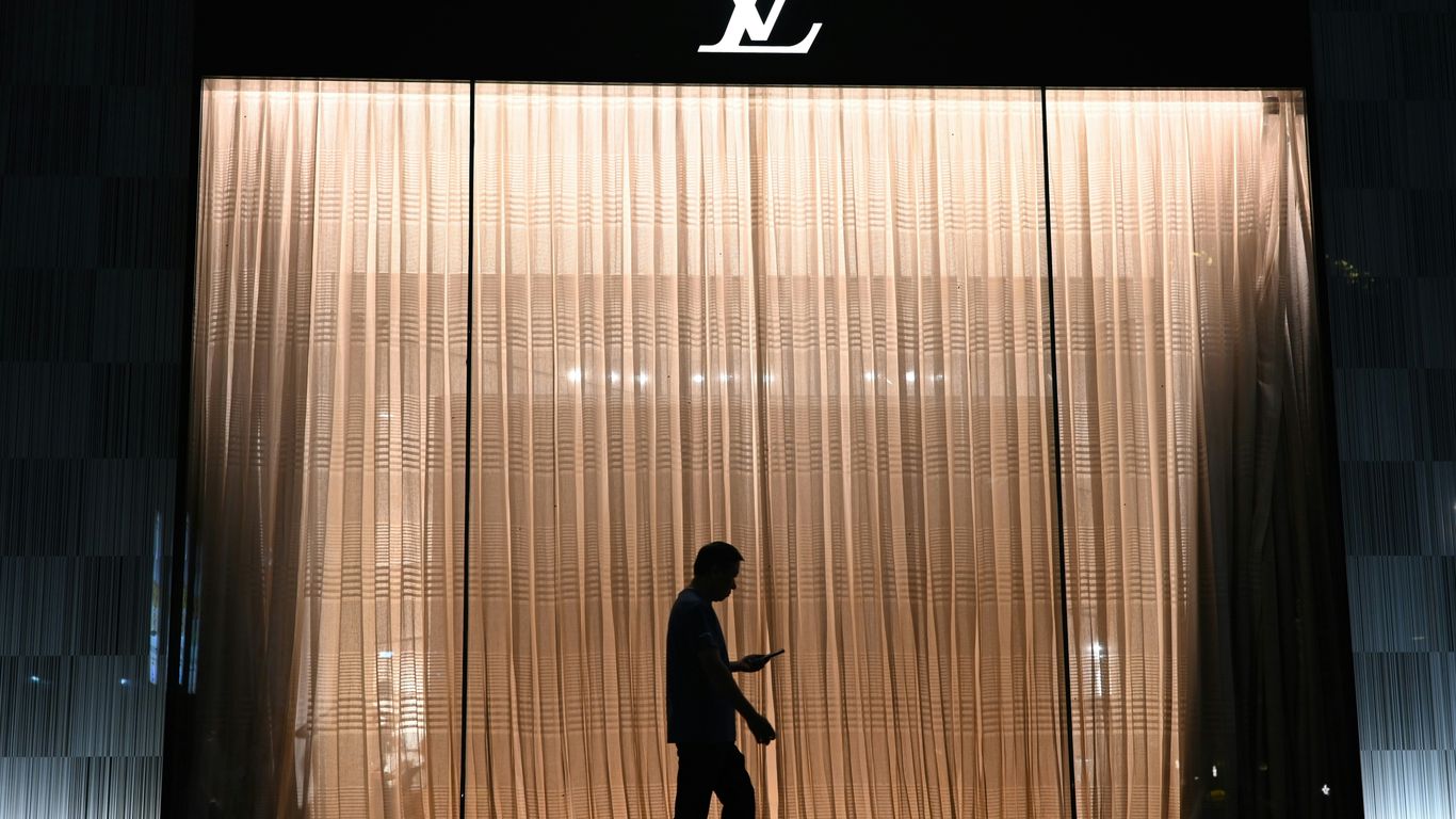 Silhouette of man in front of louis vuitton store window