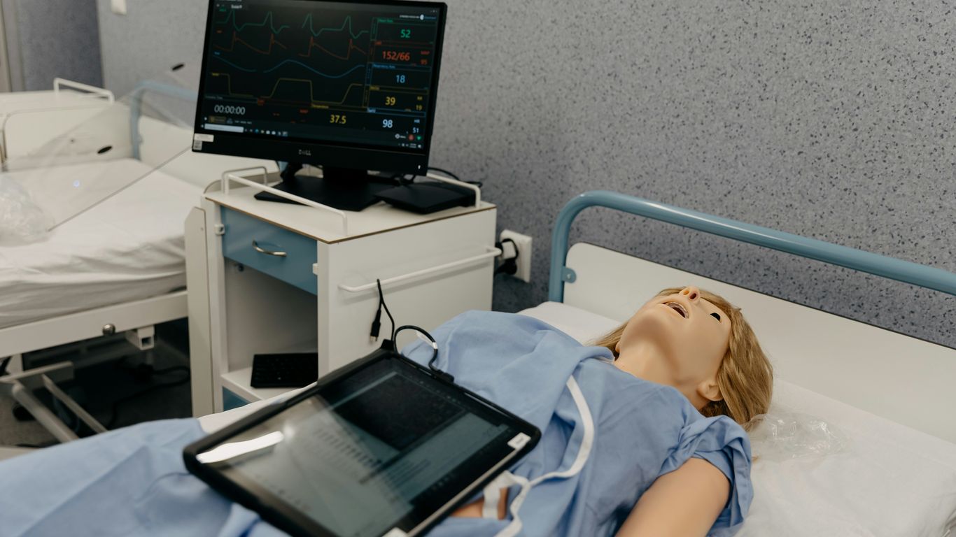 a doll laying in a hospital bed next to a monitor